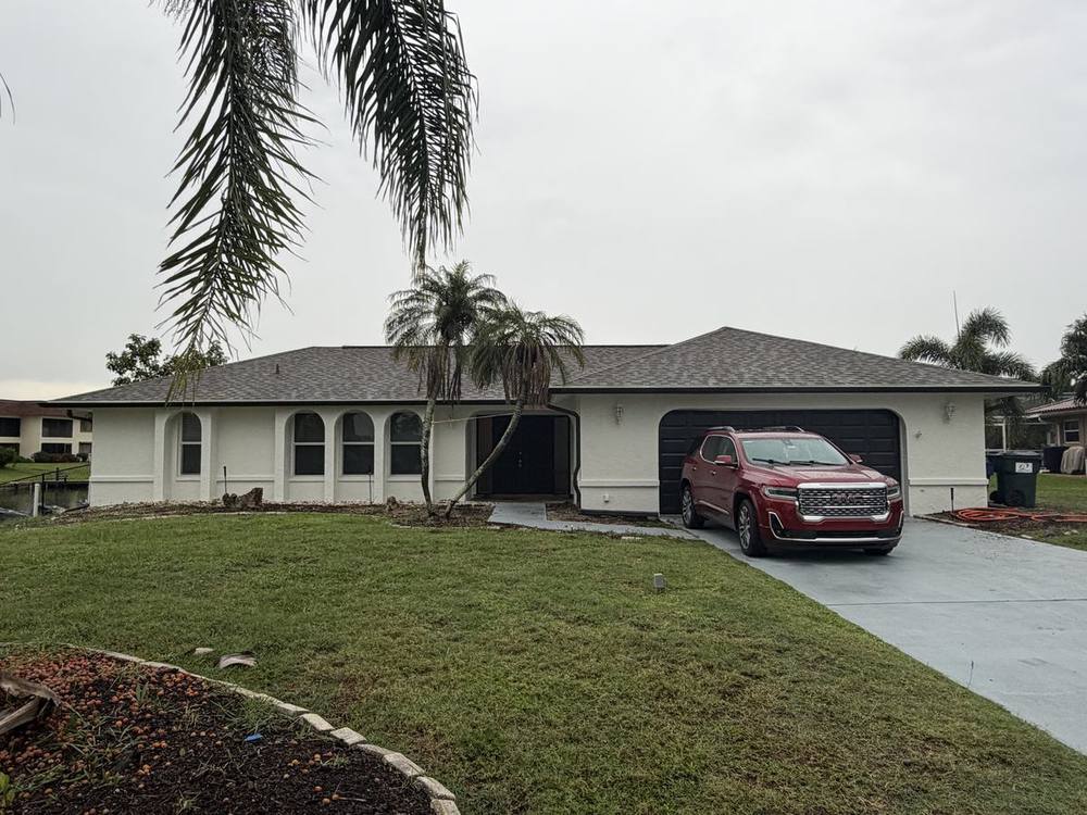 Matte black seamless gutters on white home, Cape Coral canal